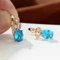 Makroaufnahme von ovalen himmelblauen Edelsteinohrringen mit Champagnervergoldung und Zirkonia - Aqua