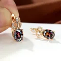 Elegante Roségold-Ohrringe mit ovalem Regenbogen-Zirkon und kleinen Diamanten auf weißem Grund - bunt