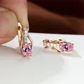 Ovale Ohrringe in Roségold mit rosa Kristallen und Zirkonia auf einem Schmuckständer - Champagner Gold Rosa
