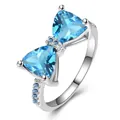 Elegant silver bow ring featuring blue triangle gemstones and sparkling zircon accents - US 7 / Platinum Plated Aqua Blue