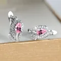 Detailopname van oorbellen met roze peervormig kristal en witte steentjes rondom - Zilver Roze