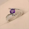 Macro detail of oval purple gemstone ring with micro-pave zircon on silver band - US 5 / Purple Zirconia