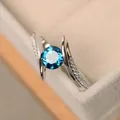 Macro shot of silver ring featuring a round blue gemstone and pavé zircon accents - US 5 / Blue Zirconia
