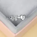 Vue rapprochée d'une bague argentée avec papillon diamanté et cœur gravé de la lettre N - Ouvert Réglable / Platine Lettre N