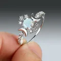 Zilveren ring met een ronde witte opaal en fonkelende accenten van een wassende maan - US 5 / Witgoud Opaal Witte Zirkonia