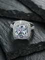 Dettaglio anello con diamante taglio cushion e doppio halo su sfondo in pietra nera - US 6 / Bianco
