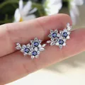 Silver flower stud earrings featuring blue gems and marquise zircon accents - Royal Blue Zirconia