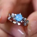 Macro shot of silver ring with blue opal and leaf-shaped cubic zirconia accents - US 6 / Blue