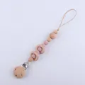 Detail of baby pacifier clip with natural beech wood rings and soft pink silicone beads - Dusty Rose