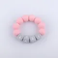 Macro shot of pink and grey silicone baby teething bracelet with square letter beads - Pink
