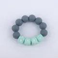 Macro detail of silicone baby teething bracelet with grey beads and mint green BABY letters - Dark Gray