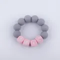 Macro detail of silicone baby teether bracelet with grey beads and pink letters spelling BABY - Gray