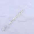 Detail of baby pacifier clip with white faux pearls and transparent plastic clamp - Clear