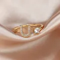 Adjustable gold letter U ring featuring shimmering pavé crystals and a round solitaire stone - Letter U / Gold