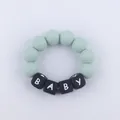 Macro shot of green silicone teether bracelet with BABY letter beads for infant teething - Light Green