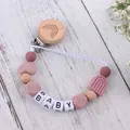 Detail of wooden rainbow pacifier clip with silicone beads and BABY letter design - Dusty Rose