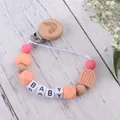 Close-up of rainbow silicone pacifier clip with wood beads and BABY letter beads - Rose Pink