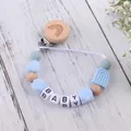 Detail of wooden rainbow baby pacifier clip with silicone beads and BABY letter charms - Blue
