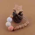 Détail de l'attache-tétine en bois avec perles au crochet, pomme de pin et perles BABY - Étoile