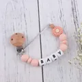 Daisy silicone teether pacifier clip with baby letter beads on white wood surface - Rose Pink