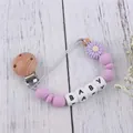 Close-up of lavender daisy silicone pacifier clip with BABY letters and wooden clip - Purple
