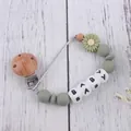 Detailed view of silicone baby pacifier clip with green daisy and wooden beads - Bean Green