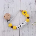 Detailed macro view of daisy silicone baby pacifier chain with wooden clip and beads - Yellow
