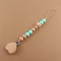 Close-up of wooden heart pacifier clip with mint green silicone beads on warm background - Mint Green