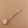 Detailed view of heart-shaped wooden pacifier clip with silicone beads for baby teething - Khaki