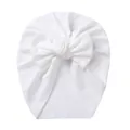 Close-up of white ribbed knit fabric texture and bow detail on the baby turban hat - White