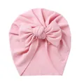 Detail of baby turban hat featuring pink ribbed knit fabric and a large soft bow decoration - Pink