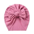 Detail of baby pink turban hat featuring ribbed fabric texture and a large soft bow - Rose Red