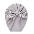 Detail of baby turban hat featuring a large floral bow on soft purple-grey fabric - Grey Floral