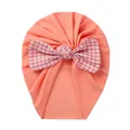 Detail of coral orange baby turban hat featuring a red and white checkered bow tie - Peach Floral