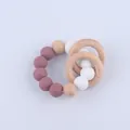 Macro detail of silicone and beech wood teething rings for infants in muted tones - Dark Mauve