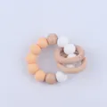 Macro detail of silicone beads and natural beech wood rings for infant teething relief - Deep Skin