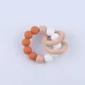 Detailed view of silicone beads and natural beech wood rings for infant teething relief - Orange