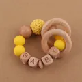 Gros plan sur l'anneau de dentition bébé en bois de hêtre avec perles en silicone jaune - Jaune Vif