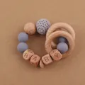 Détail d'un anneau de dentition pour bébé avec perles en bois et crochet doux - Gris