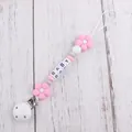 Detail of baby pacifier clip with pink flower beads and white BABY letter squares - Pink