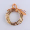 Set di bracciali in silicone glitterato con fiocco arancione e boccole dorate - Oro