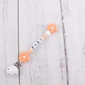 Detail of baby pacifier clip with silicone flowers, letter beads, and secure white clamp - Rose Pink
