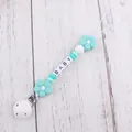Close-up of silicone pacifier clip with mint green beads and BABY letter blocks - Lake Blue