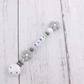 Close-up of grey and white silicone flower pacifier clip with BABY letter beads - Gray