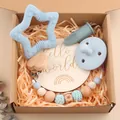 Detailed view of baby gift set with star wooden teether and silicone pacifier accessories - Blue