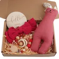 Detailed close-up of a baby gift set with rabbit plush, headband, and wooden pacifier chain - Red