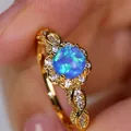 Macro shot of vintage gold flower ring featuring blue opal and intricate twisted rope band - US 5 / Gold Blue