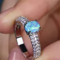 Macro shot of oval blue opal ring with pave-set sparkling zircons on silver band - US 6 / Platinum Blue Opal