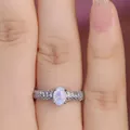 Macro shot of oval opal ring with triple-row pavé set cubic zirconia on silver band - US 6 / Platinum White Opal