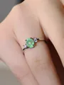 Gros plan d'une bague en argent avec opale verte ovale et pierres latérales au doigt - US 5 / Plaqué Platine Vert